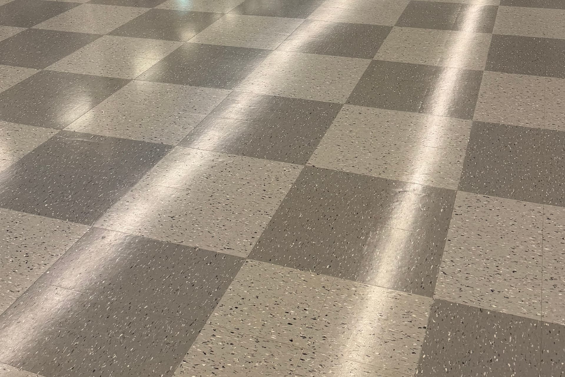 Sunlight falling across a freshly stripped and waxed checkerboard tile floor
