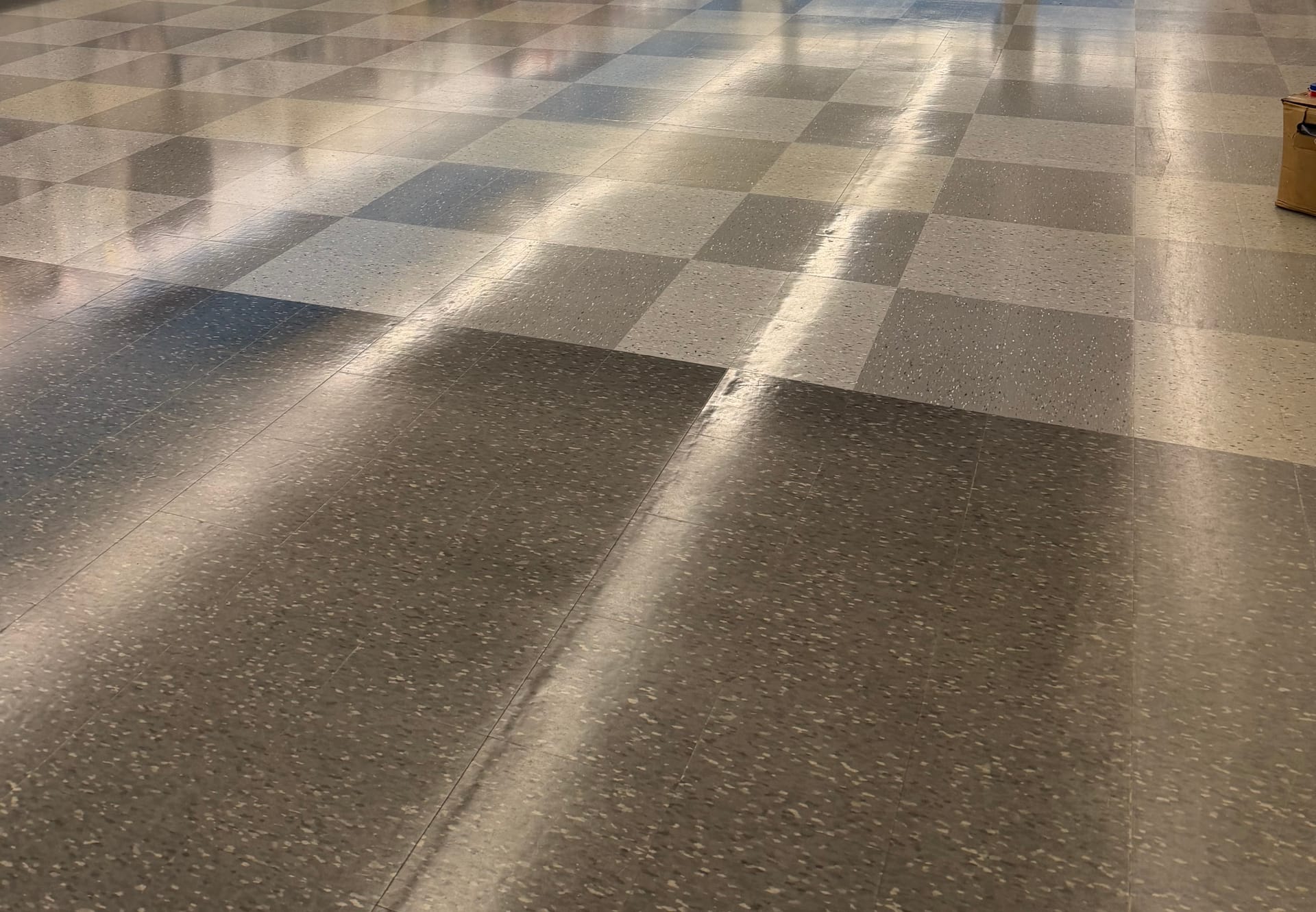 A high-gloss vinyl tile sales floor reflecting the light after a strip and wax